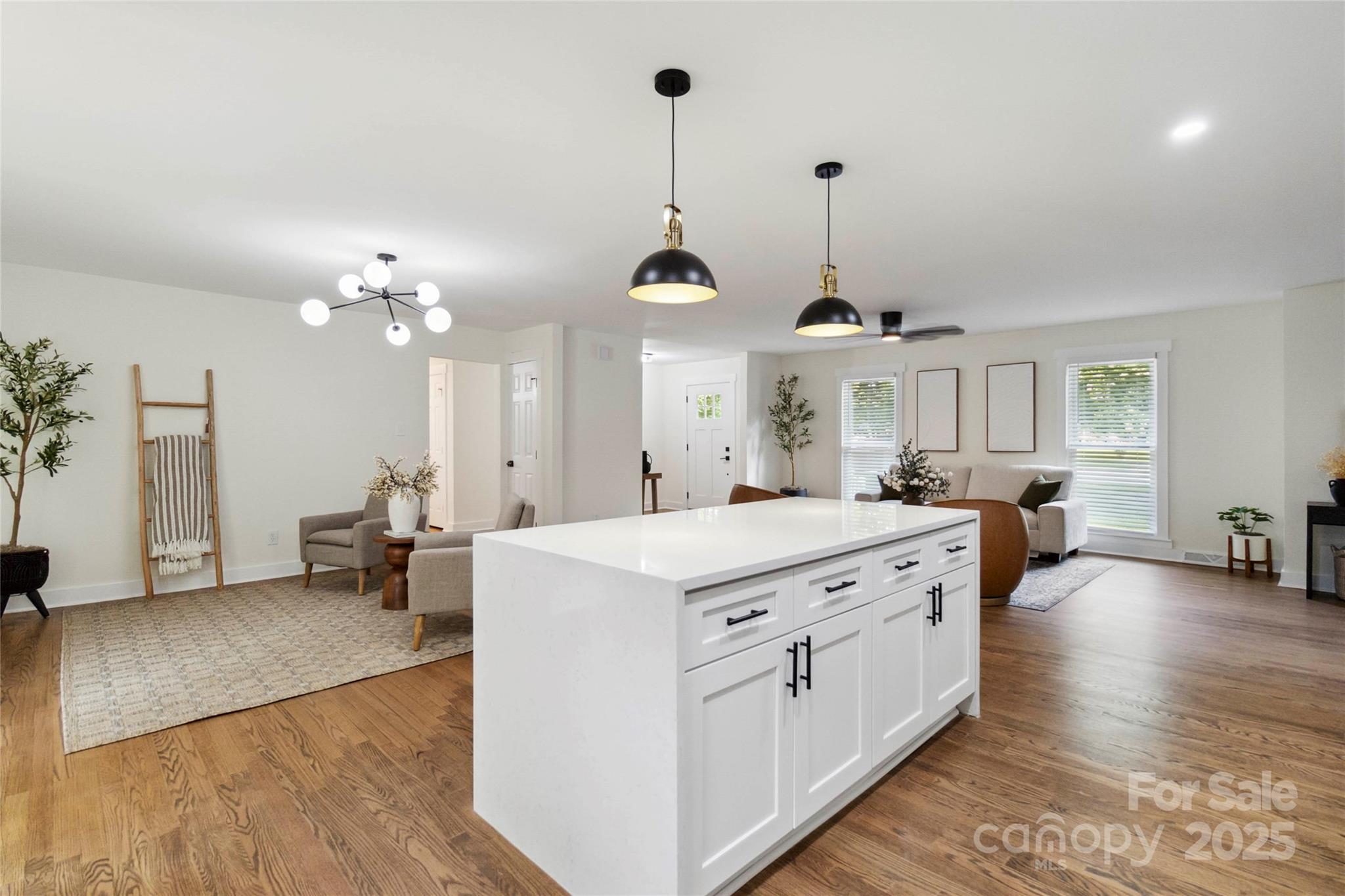 3801 Rea Road Charlotte, NC 28226 - Photo 17 of 47 a large room with kitchen island a chandelier wooden floor and a view of living room