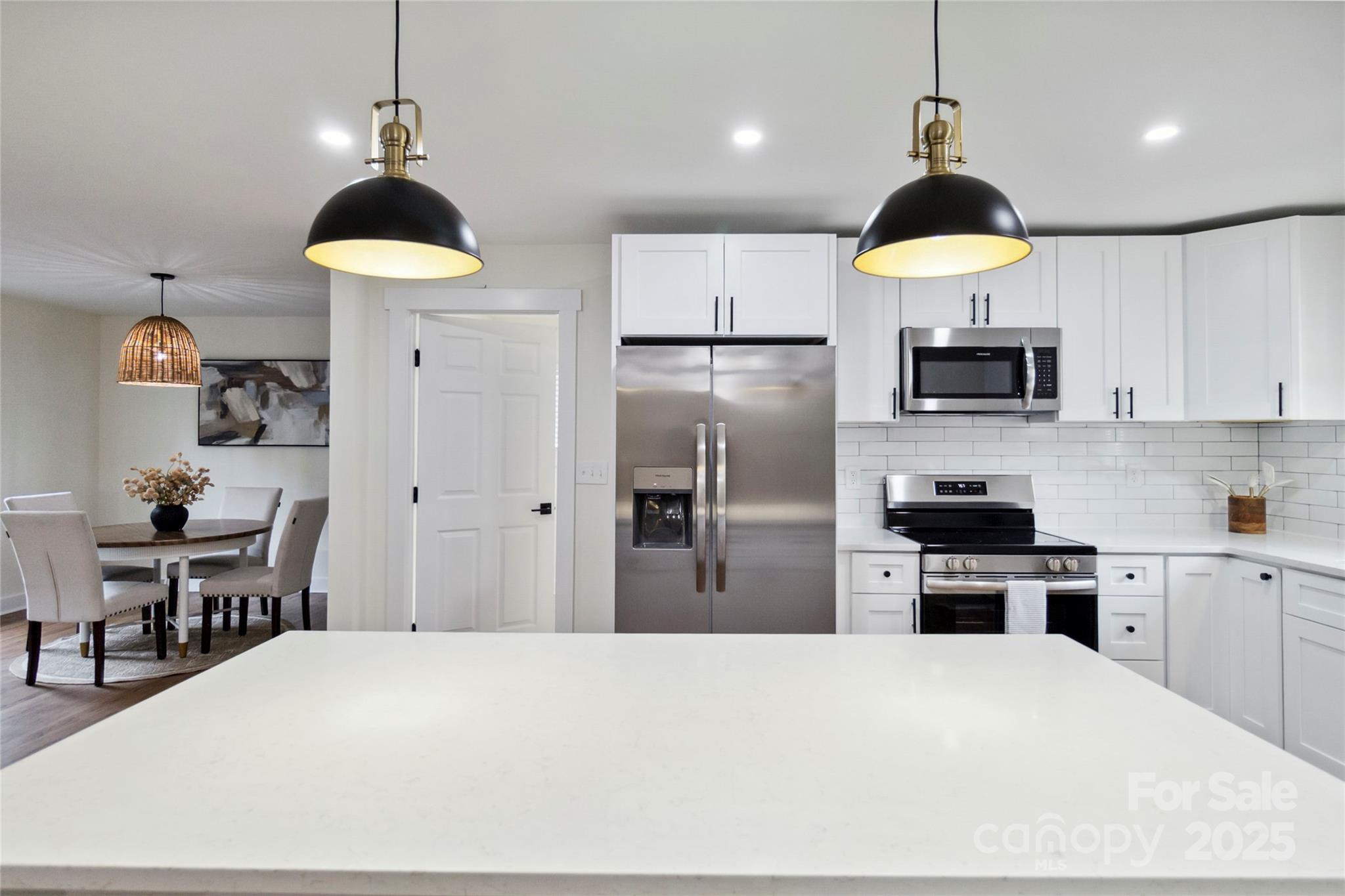 3801 Rea Road Charlotte, NC 28226 - Photo 21 of 47 a kitchen with stainless steel appliances a refrigerator a stove a sink dishwasher a dining table and chairs with wooden floor