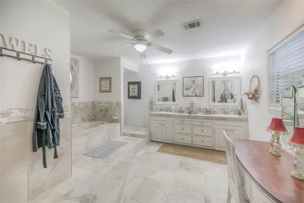 a kitchen with stainless steel appliances granite countertop a sink dishwasher a stove and white cabinets with wooden floor