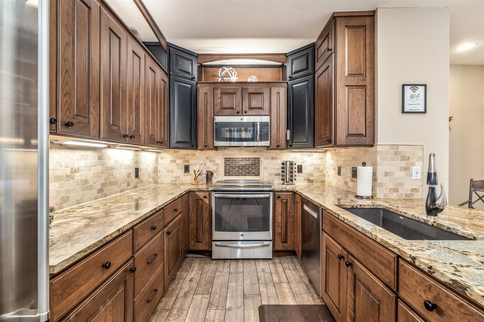 1203 West Keystone Road, Unit 2709 Keystone, CO 80435 - Photo 6 of 48 Kitchen featuring a sink, appliances with stainless steel finishes, light wood-style floors, backsplash, and light stone counters