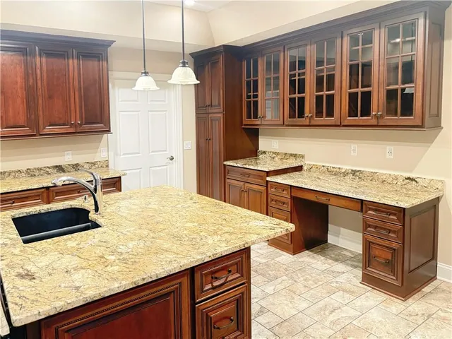 a kitchen with kitchen island granite countertop a stove refrigerator and microwave