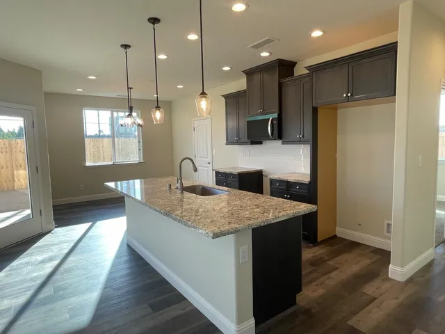 a kitchen with kitchen island a sink stainless steel appliances and cabinets