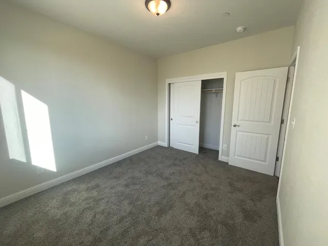 an empty room with windows and closet