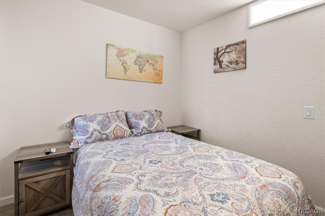 760 Blue Jay Road, Unit 26 Big Bear Lake, CA 92315 - Photo 14 of 35 a bedroom with a bed and a wall painting
