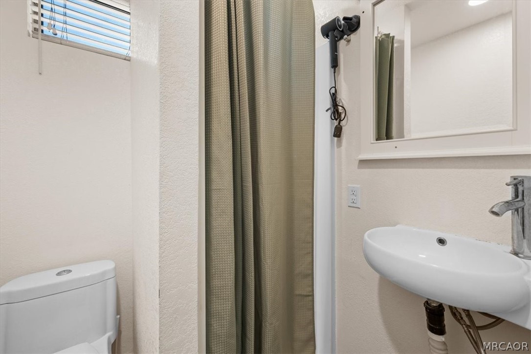 760 Blue Jay Road, Unit 26 Big Bear Lake, CA 92315 - Photo 16 of 35 a bathroom with a sink a toilet and shower