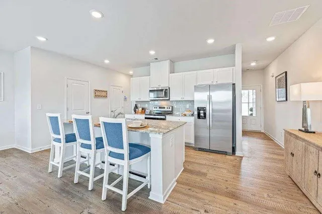a kitchen with stainless steel appliances kitchen island granite countertop a refrigerator and a stove top oven