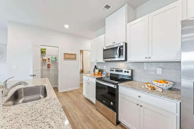 a kitchen with stainless steel appliances granite countertop a sink stove and refrigerator