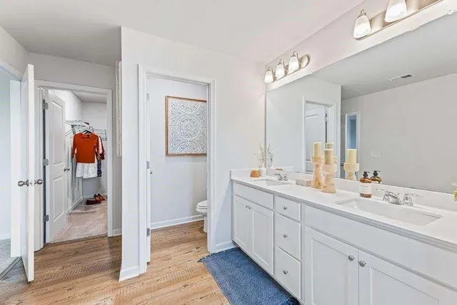 a spacious bathroom with a double vanity sink a mirror and a