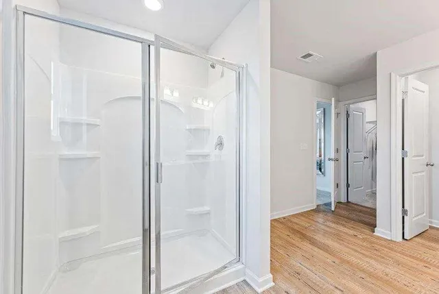 a bathroom with a shower and a glass door
