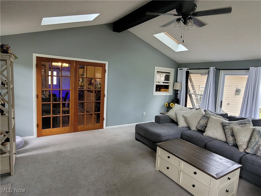 2768 Greenridge Road Barberton, OH 44203 - Photo 6 of 14 Carpeted living room with ceiling fan and lofted ceiling with skylight