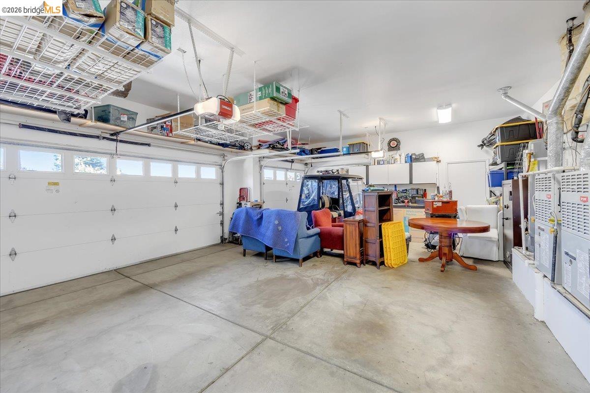 158 Rock Ridge Lane Copperopolis, CA 95228 - Photo 44 of 72 Spacious garage featuring two sectional doors with upper lites, concrete flooring, overhead storage racks, built-in cabinetry, and wall-mounted utility units