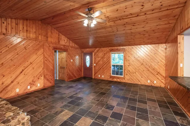 a living room with patio furniture and a flat screen tv