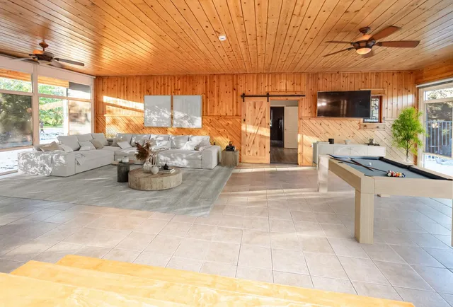 a view of an empty room with a ceiling fan and window