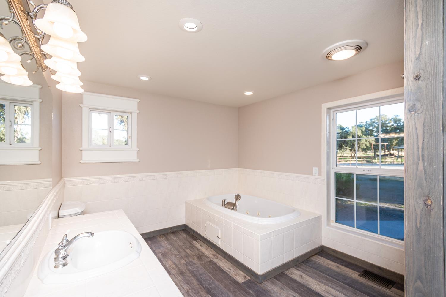 664 Perkins Road Arbuckle, CA 95912 - Photo 43 of 91 a white bath tub sitting in a spacious bathroom next to a window