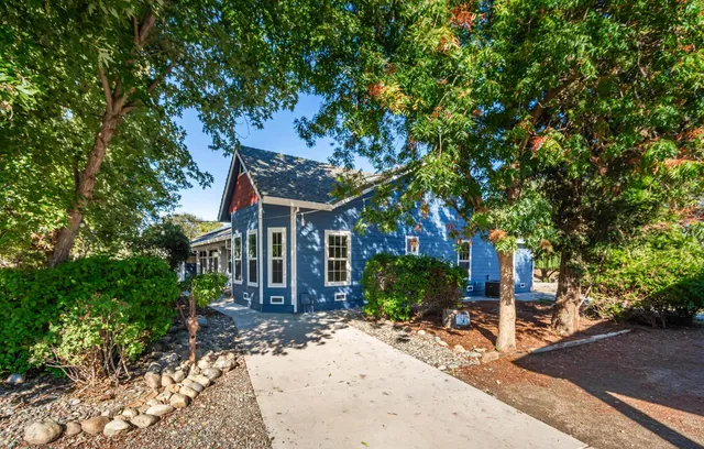 an aerial view of a city with lots of residential buildings ocean and mountain view in back