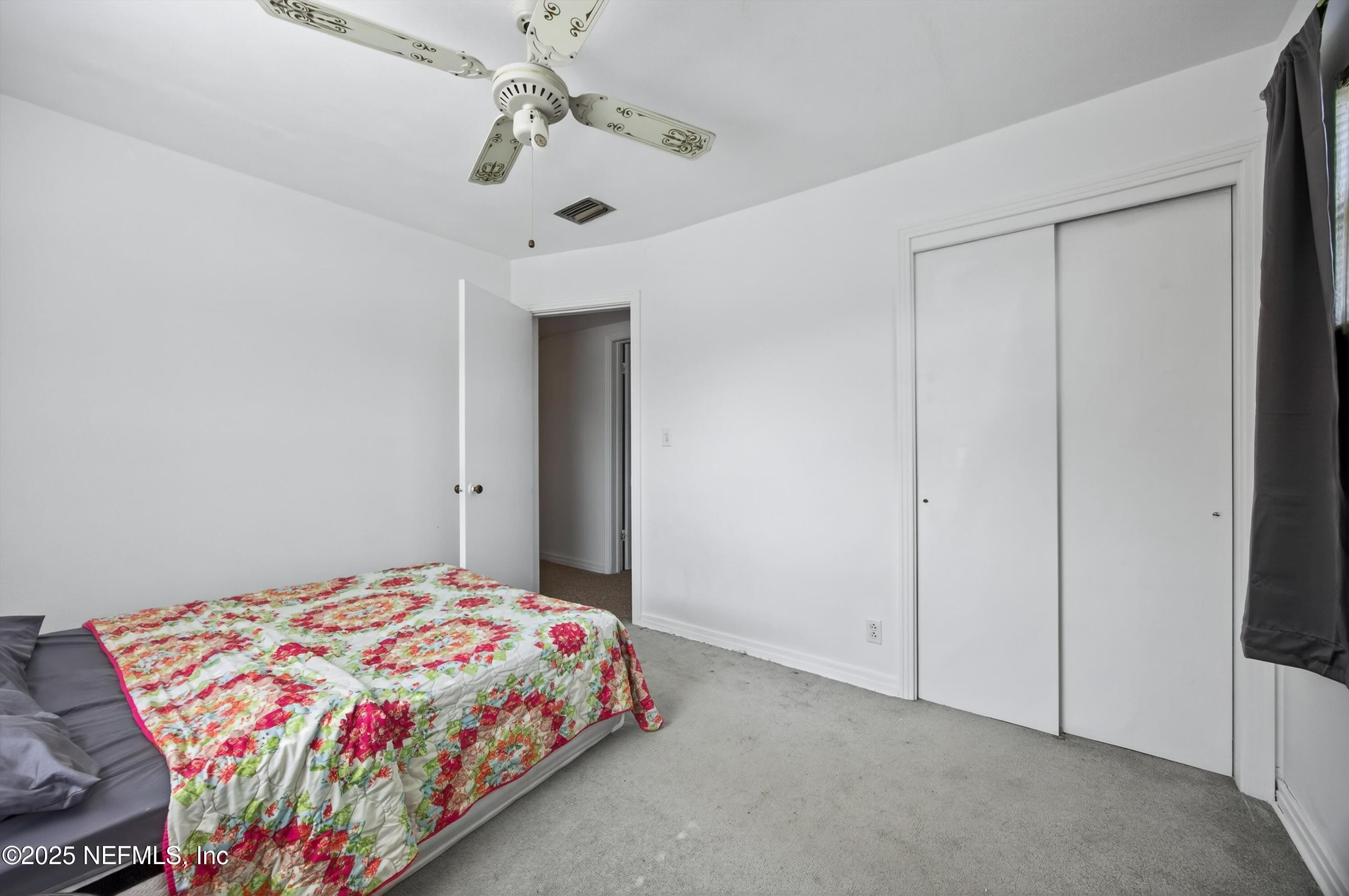 2630 Bywood Road Jacksonville, FL 32211 - Photo 21 of 35 a bedroom with a bed and a chandelier