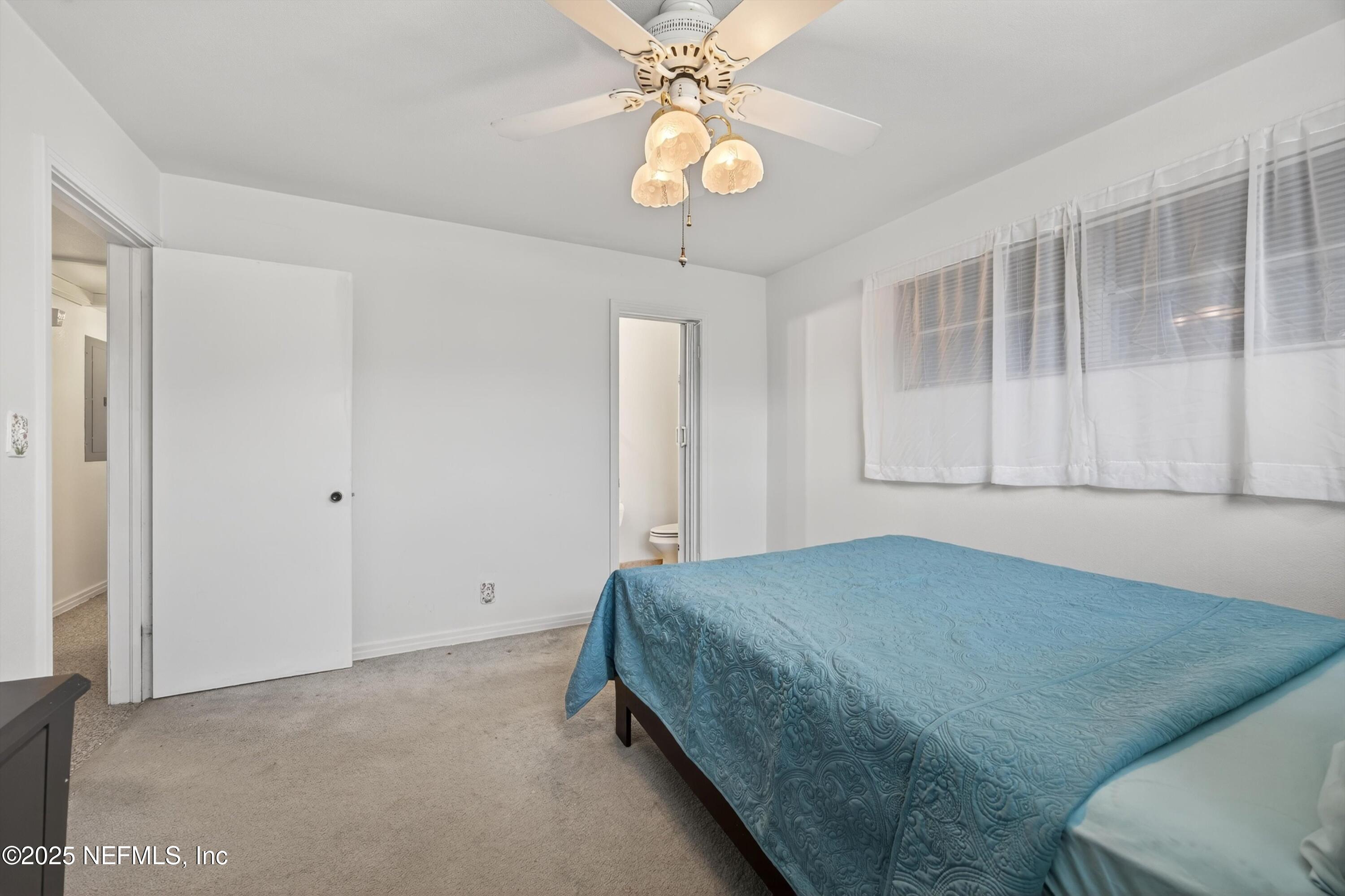 2630 Bywood Road Jacksonville, FL 32211 - Photo 25 of 35 a bedroom with a bed and a chandelier