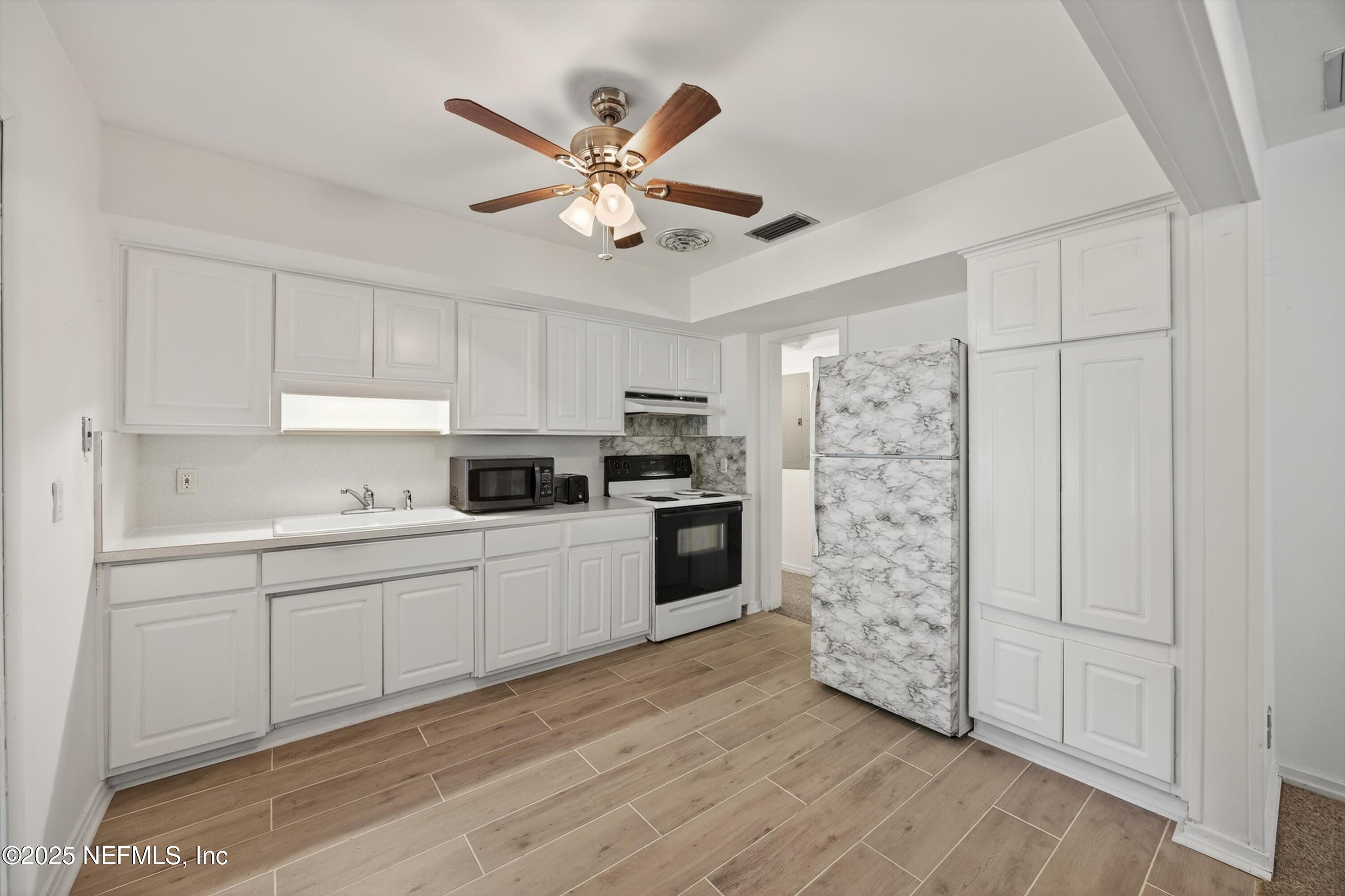 2630 Bywood Road Jacksonville, FL 32211 - Photo 10 of 35 a kitchen with stainless steel appliances a refrigerator sink and white cabinets