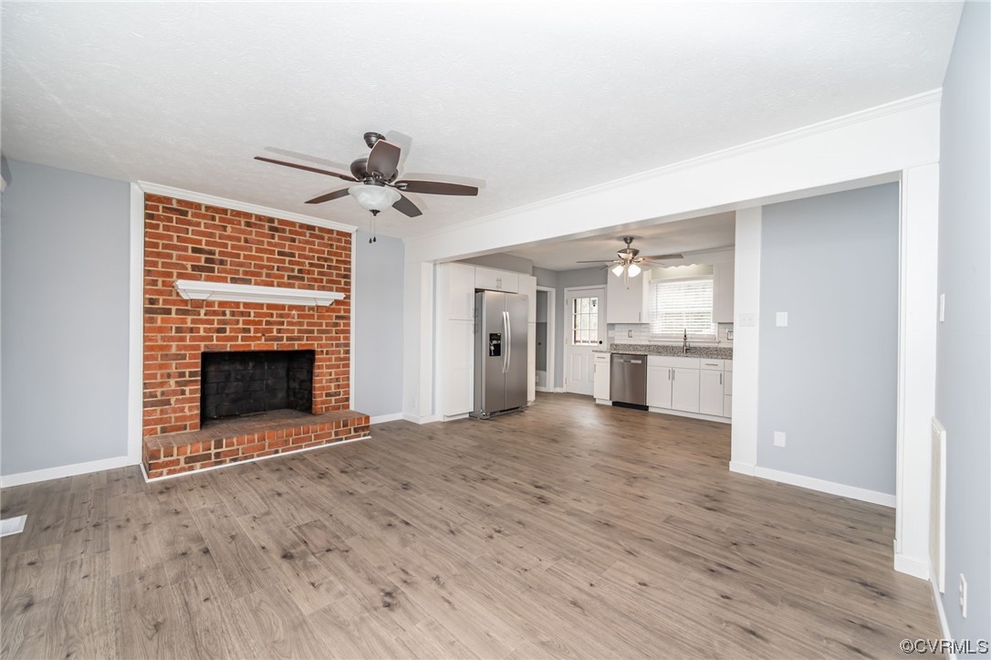 4741 Roxbury Road Charles City, VA 23030 - Photo 8 of 32 a view of a big room with wooden floor a fireplace and windows