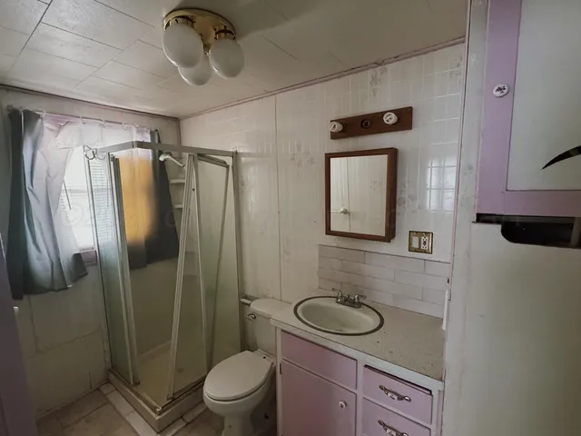 a bathroom with a granite countertop toilet sink and shower