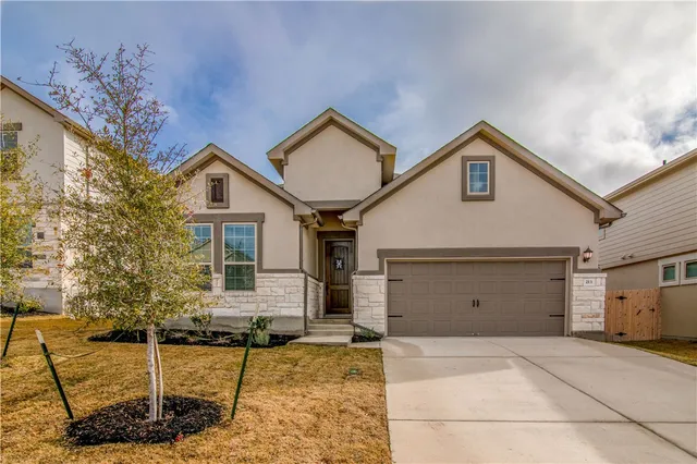 a view of a house with a yard and garage