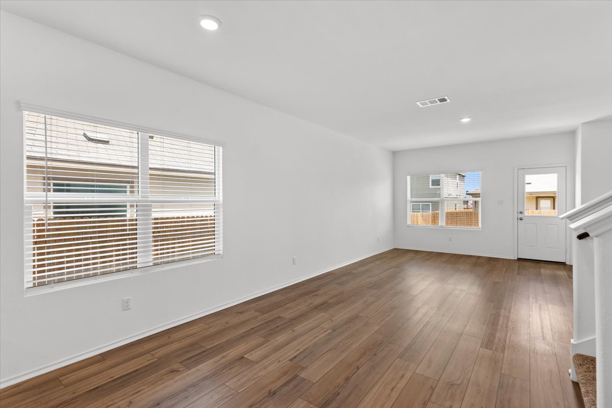 448 Perfect World Loop Jarrell, TX 76537 - Photo 13 of 40 Natural light illuminates rich hardwood flooring in this spacious, inviting room.