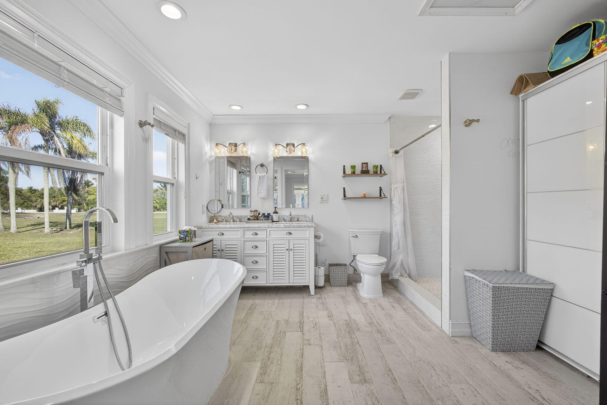 16490 Rustic Road Wellington, FL 33470 - Photo 22 of 81 a large white kitchen with a lot of white cabinets and stainless steel appliances
