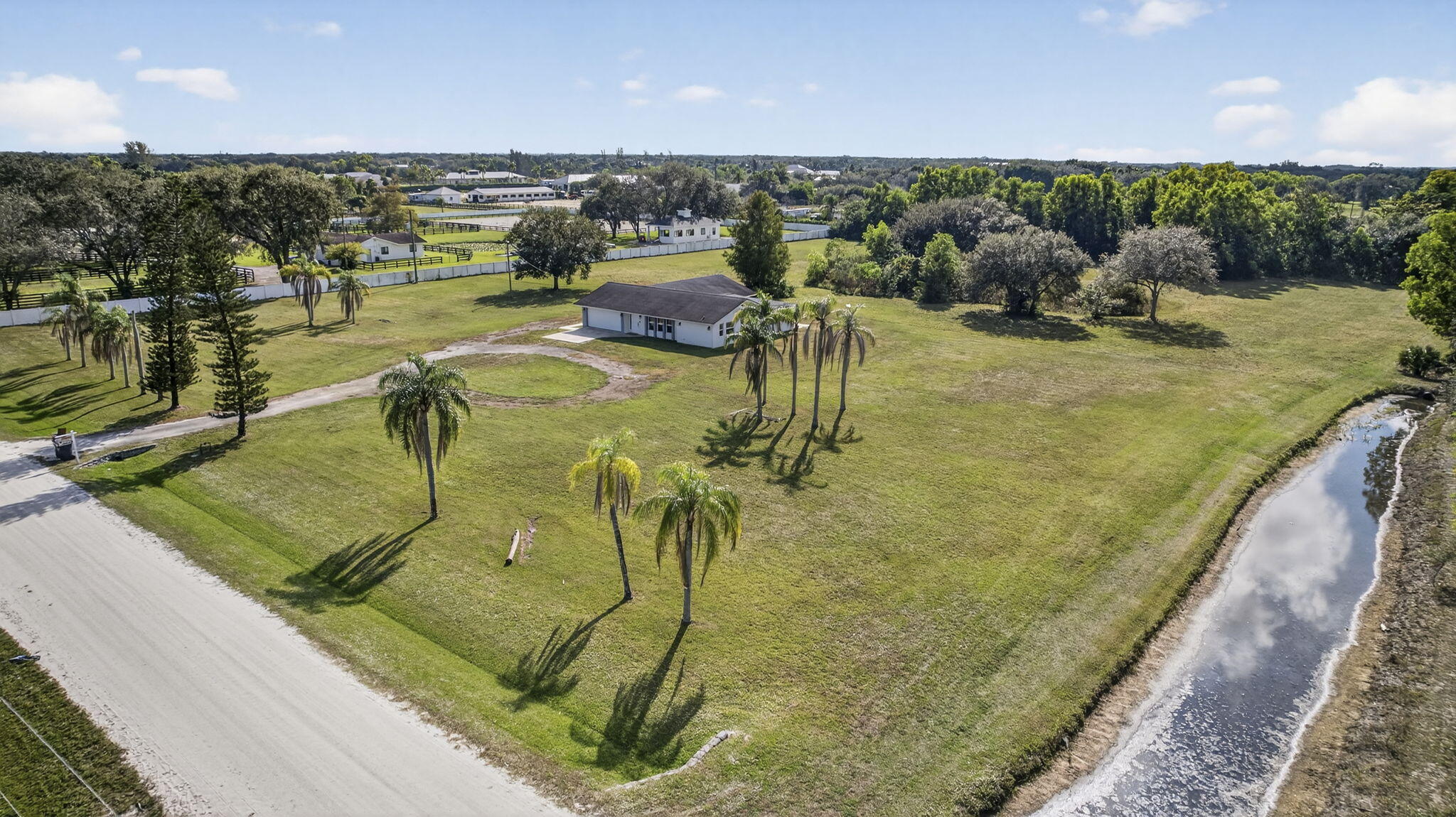 16490 Rustic Road Wellington, FL 33470 - Photo 59 of 81 a view of a swimming pool and an outdoor seating