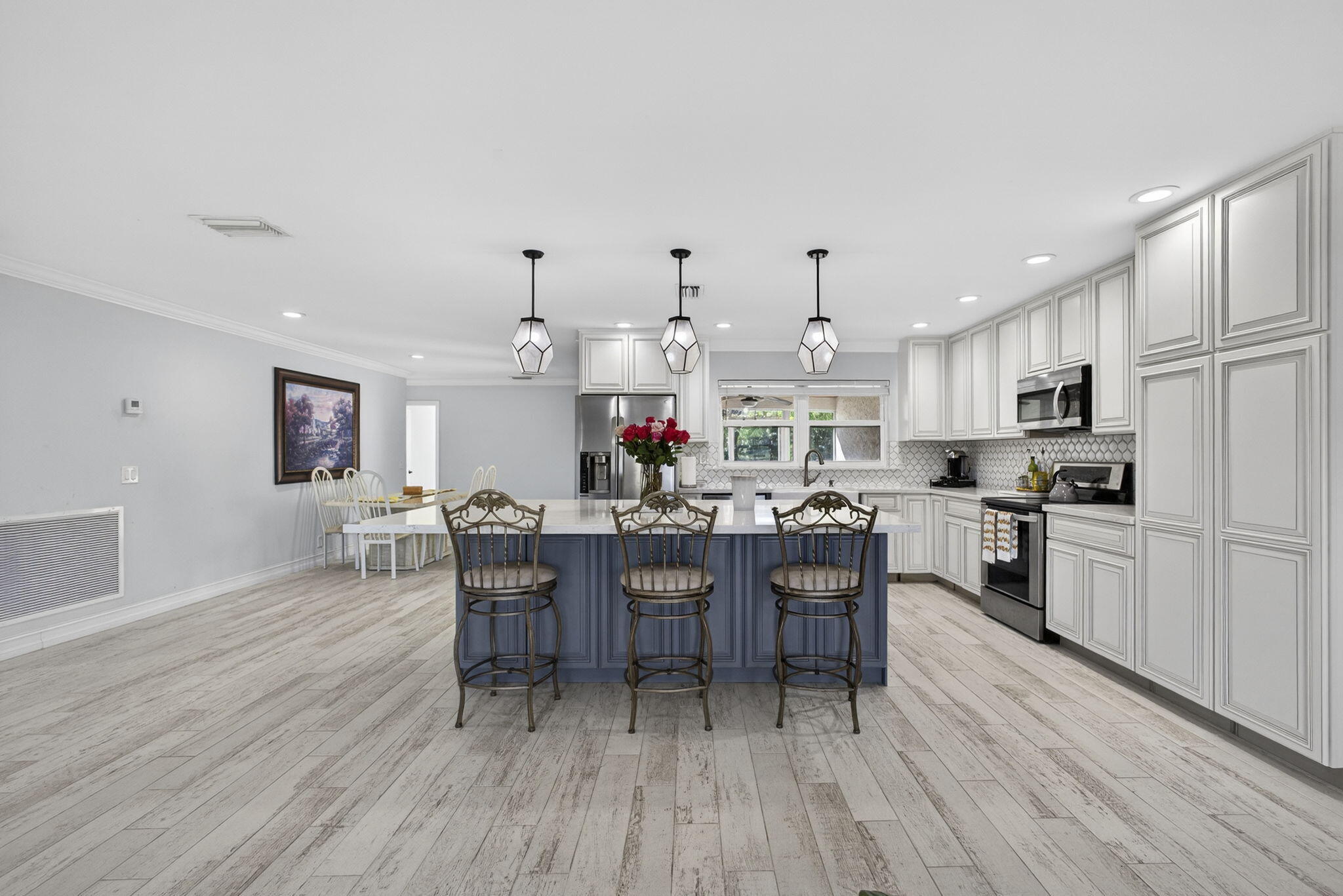 16490 Rustic Road Wellington, FL 33470 - Photo 7 of 81 a kitchen view with stainless steel appliances granite countertop a dining table chairs stove refrigerator and cabinets