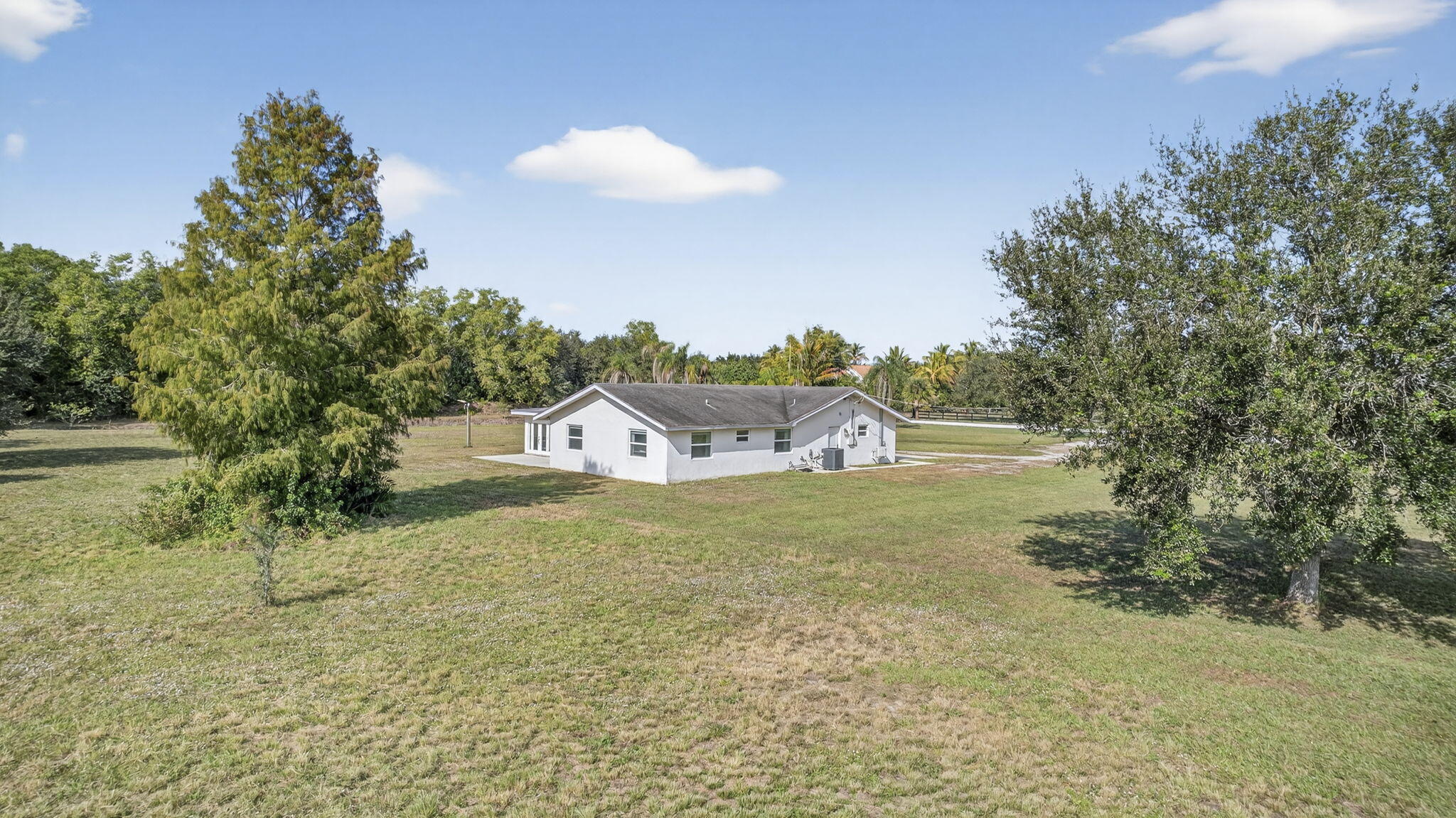 16490 Rustic Road Wellington, FL 33470 - Photo 79 of 81 a view of a house with a yard and a tree