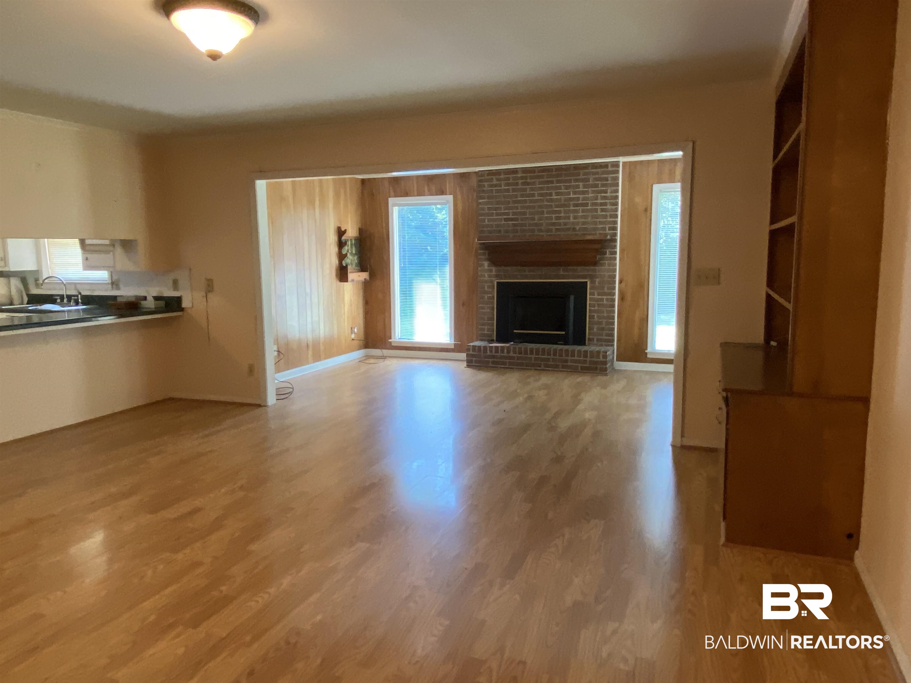 106 Terry Drive Brewton, AL 36426 - Photo 10 of 25 Unfurnished Den featuring a brick fireplace and light wood finished floors