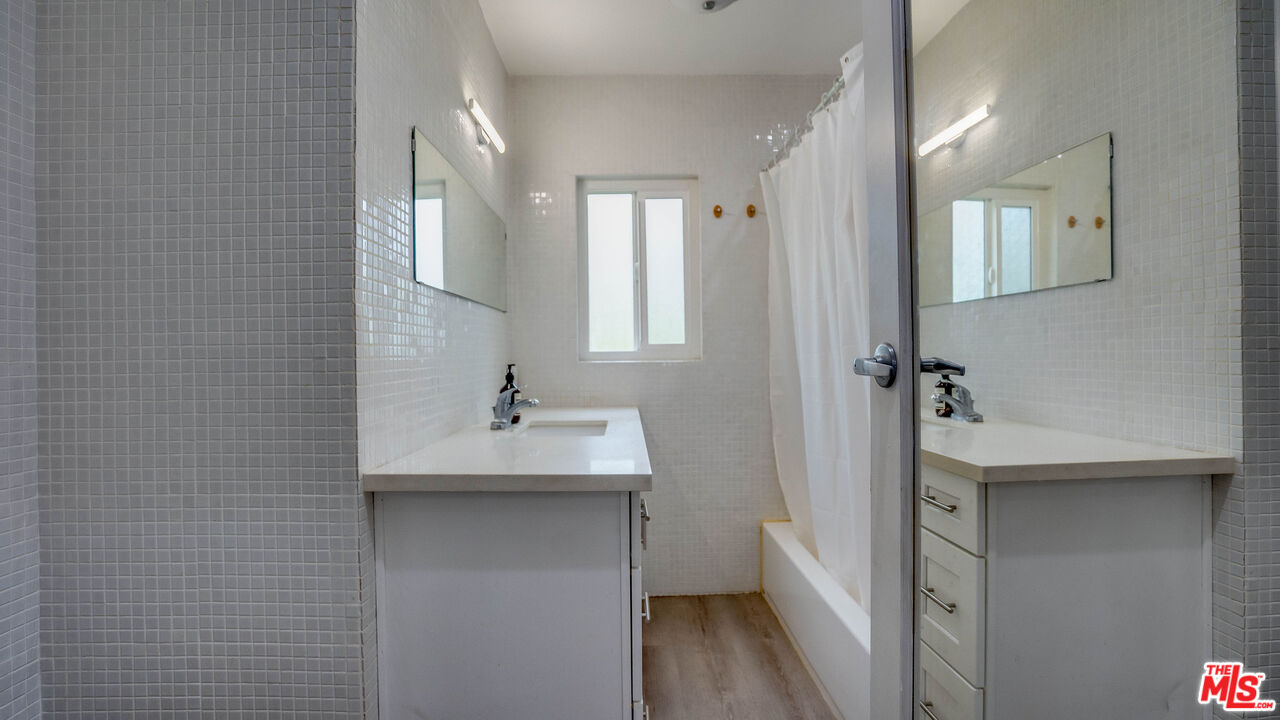 263 Flower Street Pasadena, CA 91104 - Photo 10 of 34 a bathroom with a sink a mirror and a shower