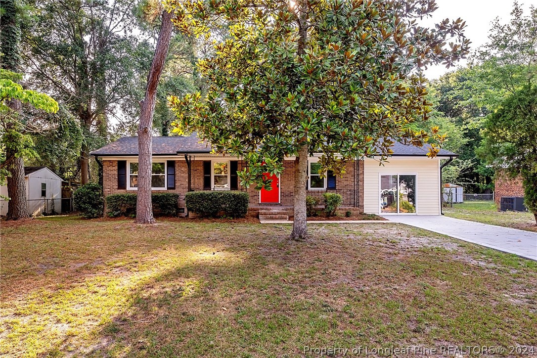 5851 Columbine Road Fayetteville, NC 28306 - Photo 1 of 25 a front view of a house with a yard and garage