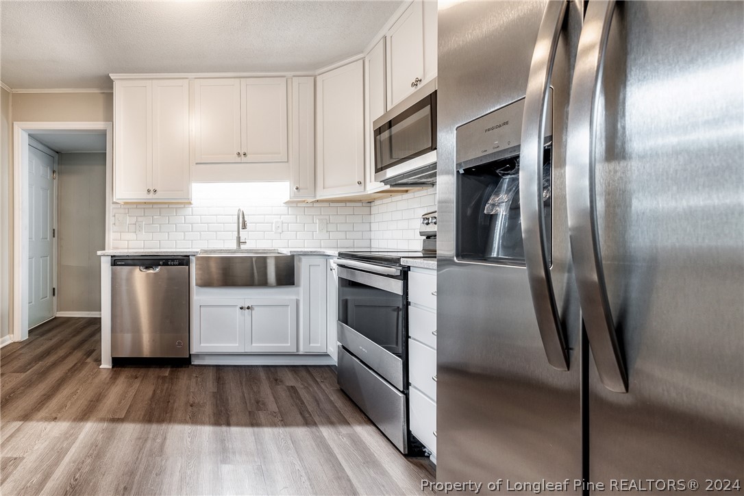 5851 Columbine Road Fayetteville, NC 28306 - Photo 12 of 25 a kitchen with stainless steel appliances a refrigerator sink and white cabinets