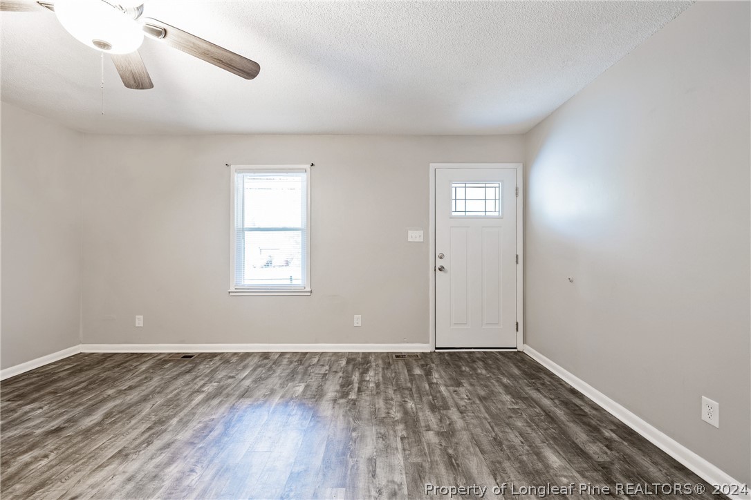 5851 Columbine Road Fayetteville, NC 28306 - Photo 5 of 25 a view of an empty room with wooden floor and a window