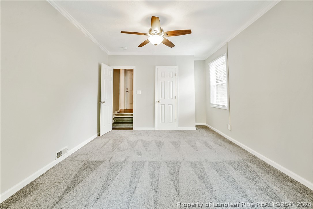 5851 Columbine Road Fayetteville, NC 28306 - Photo 8 of 25 an empty room with chandelier fan and windows