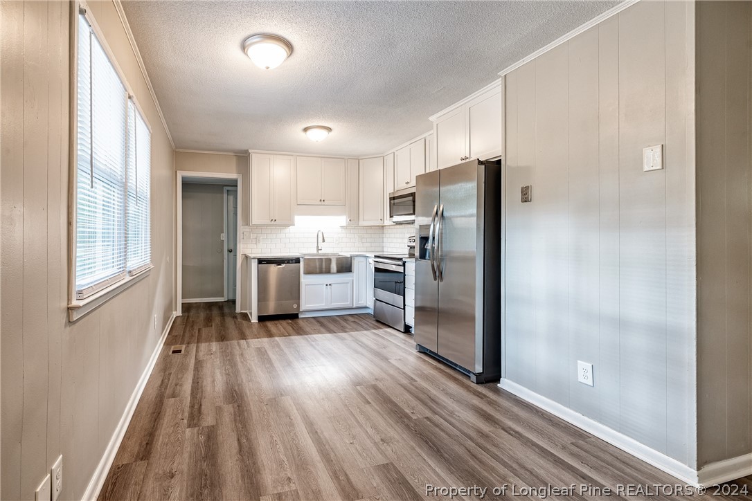 5851 Columbine Road Fayetteville, NC 28306 - Photo 10 of 25 a kitchen with a refrigerator and wooden floor