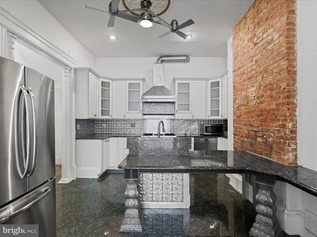 a kitchen with stainless steel appliances granite countertop a stove and a refrigerator