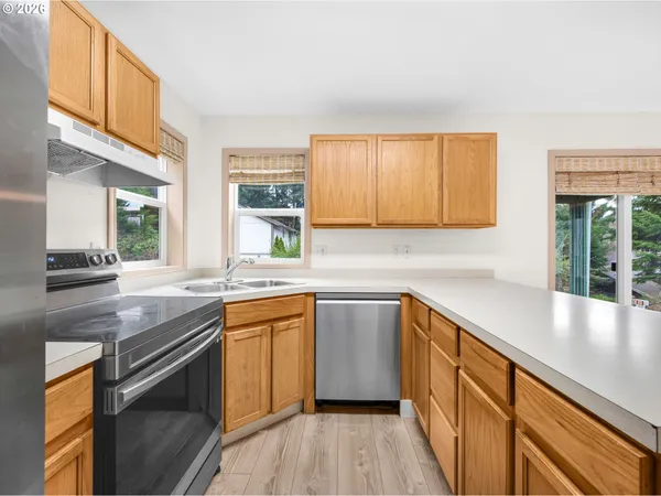 a kitchen with stainless steel appliances granite countertop a sink a stove and a wooden floors