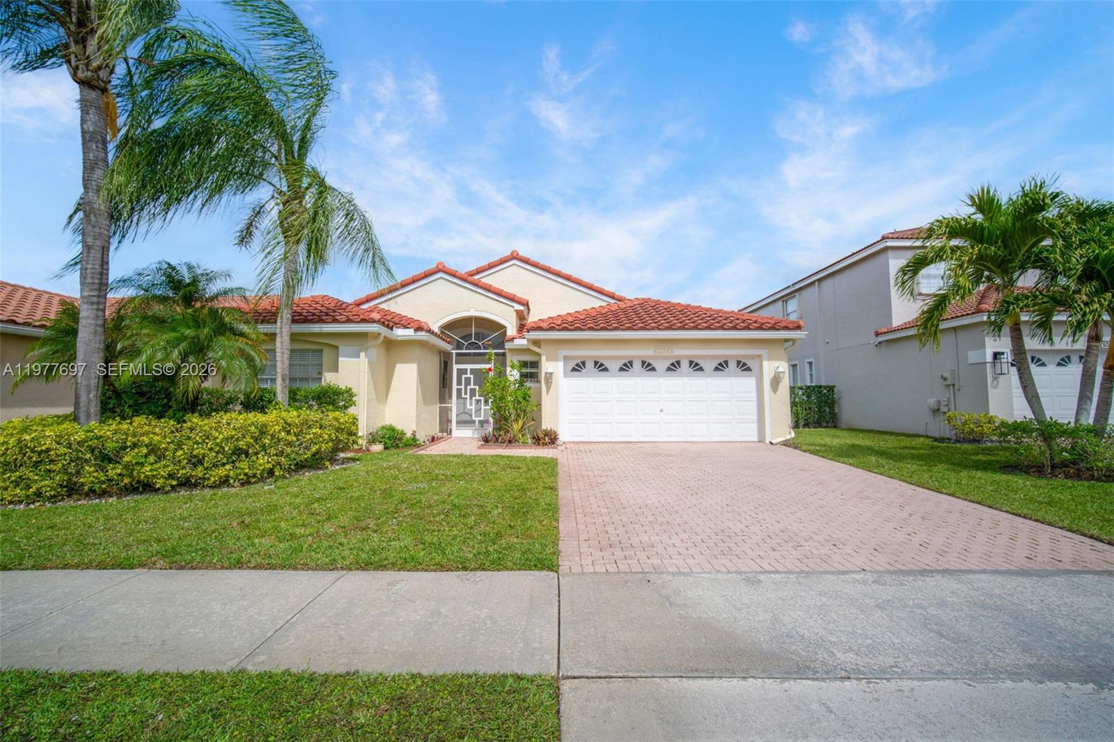 a view of a house with a yard and palm trees