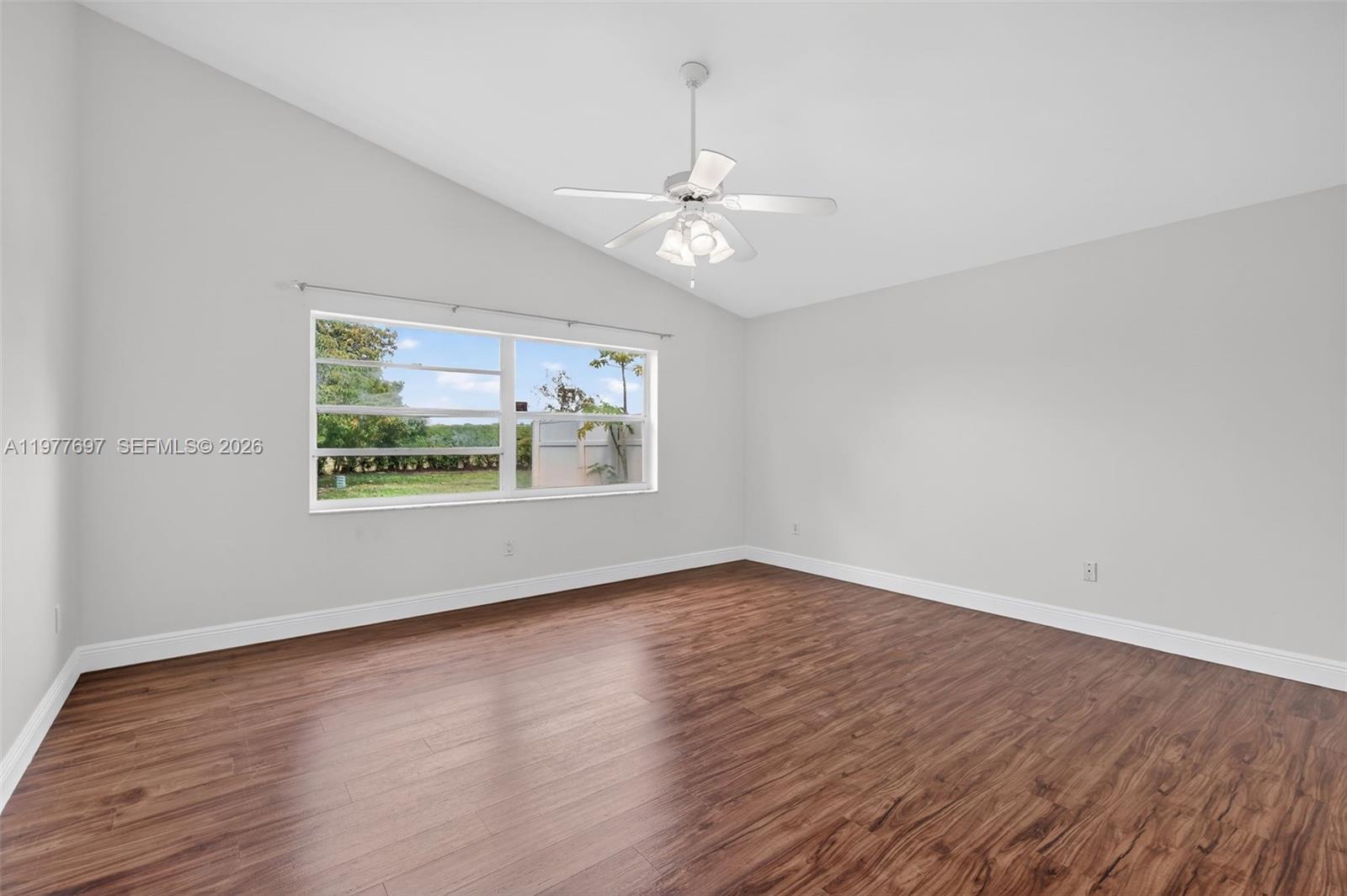 10624 Plainview Circle Boca Raton, FL 33498 - Photo 17 of 49 an empty room with wooden floor ceiling fan and window