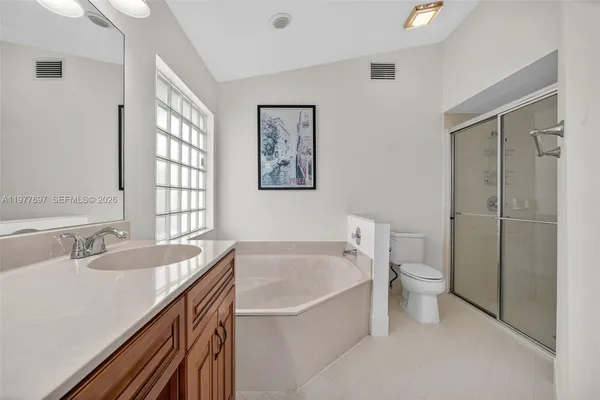 a bathroom with a granite countertop sink a toilet and shower