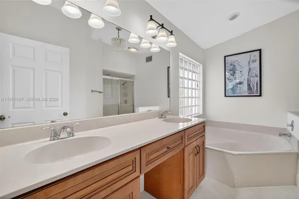 a bathroom with a granite countertop sink a large mirror and a bathtub