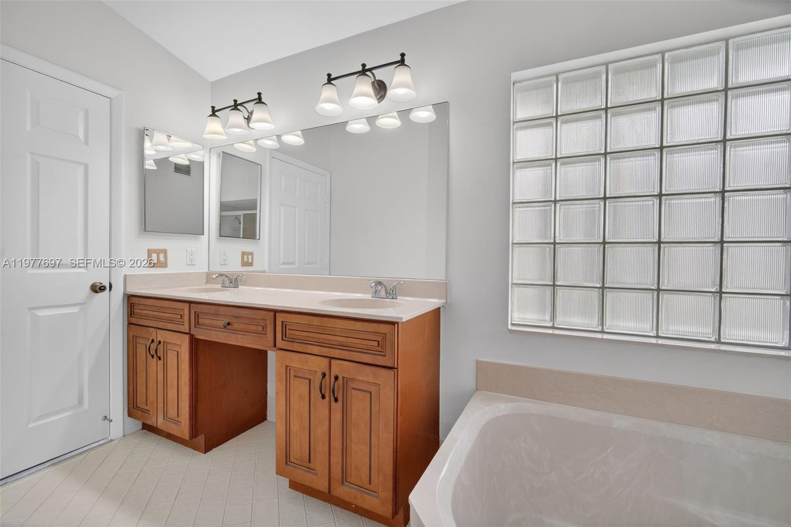 10624 Plainview Circle Boca Raton, FL 33498 - Photo 21 of 49 a spacious bathroom with a double vanity sink large mirror and a bathtub