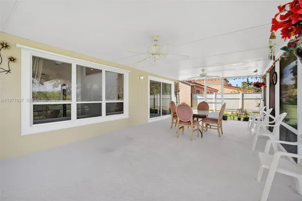 a dining room with furniture and a floor to ceiling window