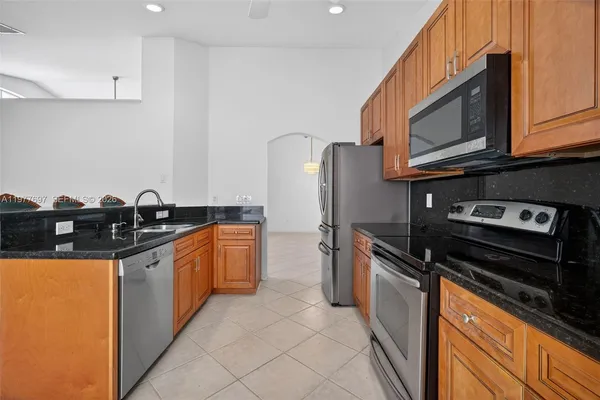 a kitchen with granite countertop stainless steel appliances and wooden cabinets