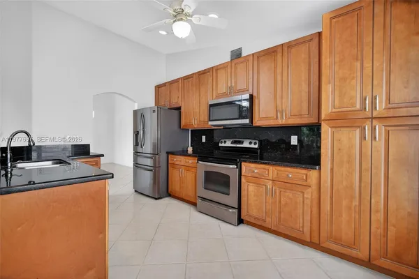 a kitchen with stainless steel appliances granite countertop a refrigerator sink and cabinets
