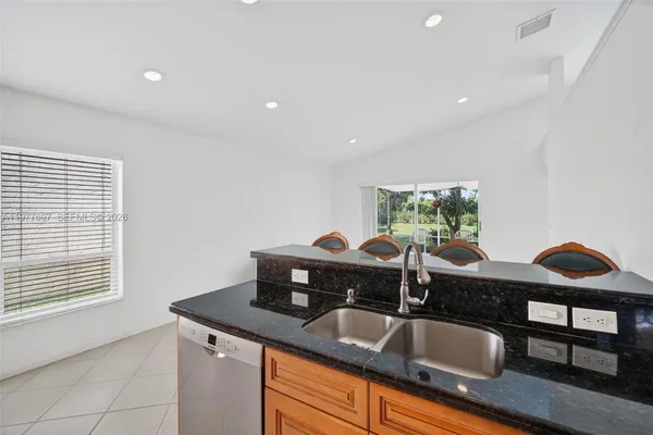 a kitchen with granite countertop a sink and a wooden floor