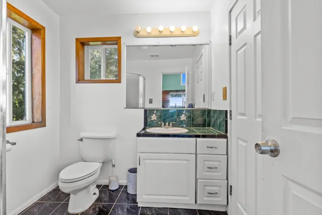 a bathroom with a toilet sink and mirror