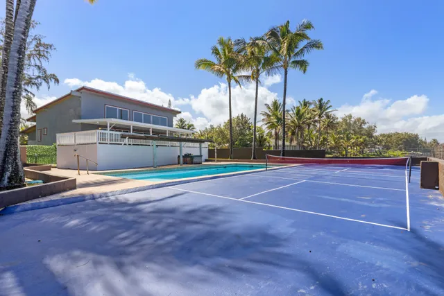a swimming pool with lawn chairs under an umbrella